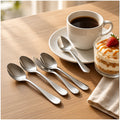Cucharitas de acero inoxidable sobre una mesa de desayuno con café y postre
