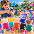Niño jugando con pistola de hidrogel junto a bolsas de balas de colores