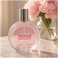 Perfume Indian Collection sobre un tocador de mármol con flores rosadas
