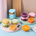 Táperes herméticos de 150 ml con frutas y snacks sobre la mesa de la cocina