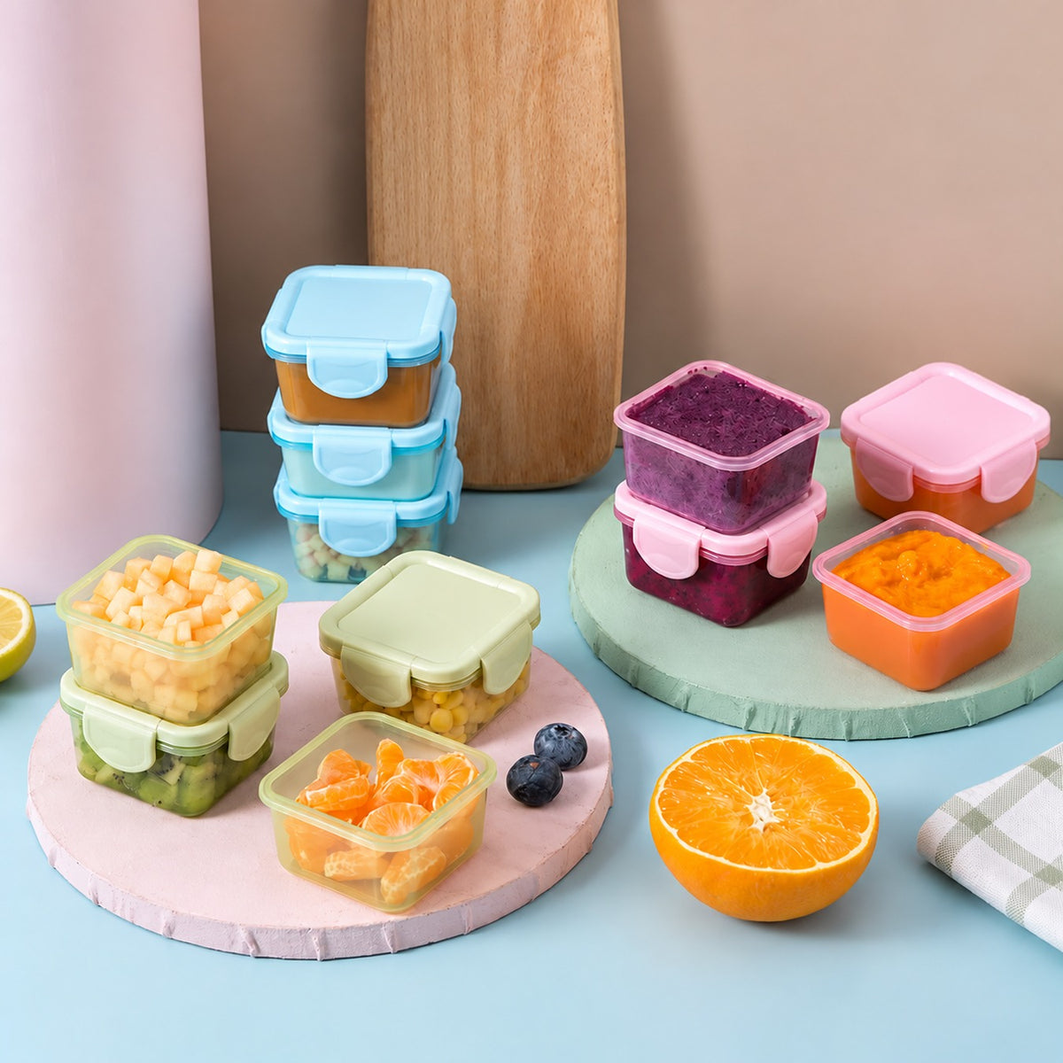 Táperes herméticos de 150 ml con frutas y snacks sobre la mesa de la cocina